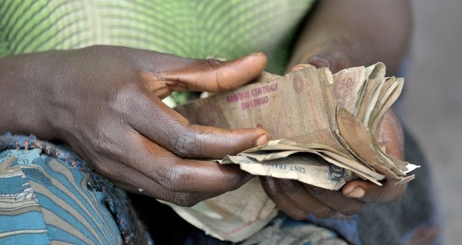 A woman counts her money in a market in Kamina, in the Democratic Republic of the Congo. Constructed by the United Methodist Committee on Relief (UMCOR), the market provides local residents a healthy environment to sell their products.